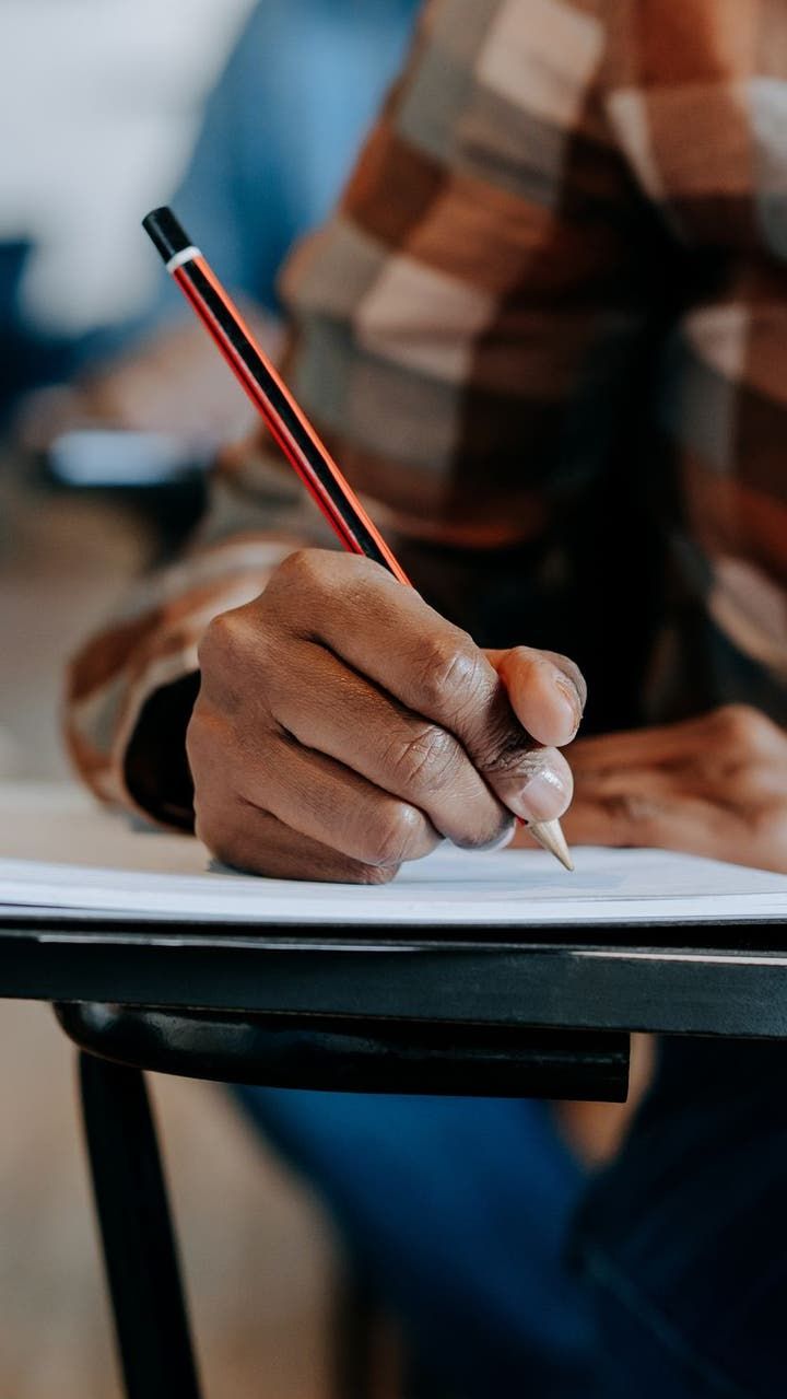 Student carefully writing in a notebook
